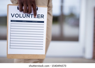 A Closeup Shot Of A Person Holding A Volunteer Sign Up Sheet With A Blurred Background