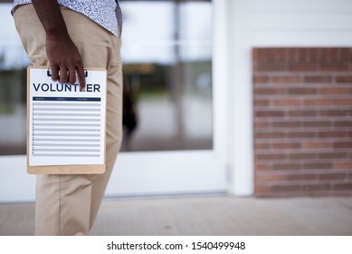 A Closeup Shot Of A Person Holding A Volunteer Sign Up Sheet With A Blurred Background