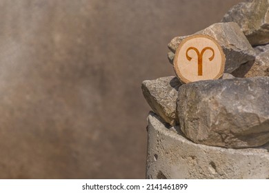 Close-up shot of a piece of wood with a zodiac sign engraved on it, especially the aries sign - Shutterstock ID 2141461899