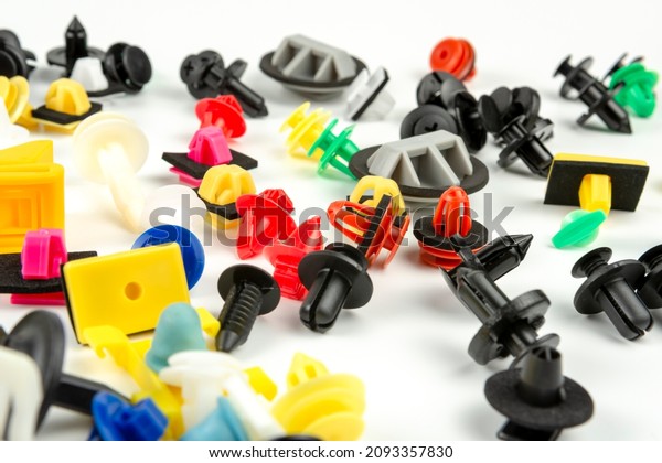 Close-up shot of plastic colored clips for the\
car.Abstract background. Panel plastic rivets isolated on white\
background. Auto plastic clasps. Insulated clip or automatic\
plastic clasp