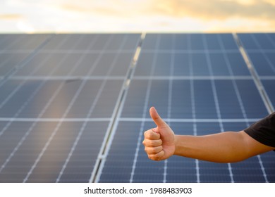 Close-up Shot Poses Positive Gesture On Solar Panel Photovoltaic On The Roof Of The House And With A Thumbs Up Or Like Money Saving And Clean Energy Ideas