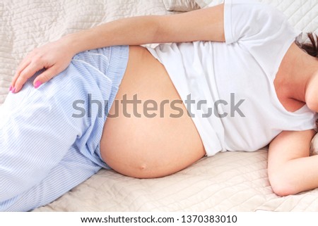 Closeup shot of pregnant woman in a bed