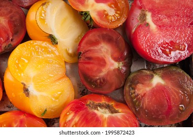 A Closeup Shot Of Red And Yellow Heirloom Tomatoes Sliced In Half