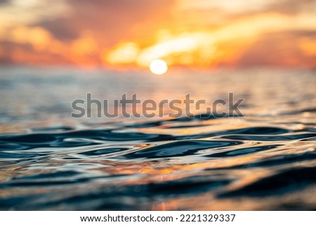 A closeup shot of a reflective sunset over blue waves