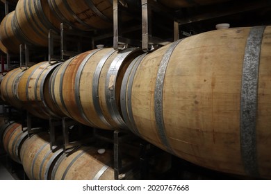 A Closeup Shot Of Rows Of Wine Barrels Aging Wine In A Winery In Texas