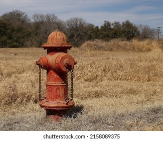 A Close-up Shot Of A Rusty Fire Hydrate Equipment In The Dry Grass 