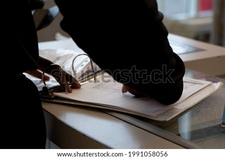A closeup shot of a security guard checking out his shift of attendance and time 