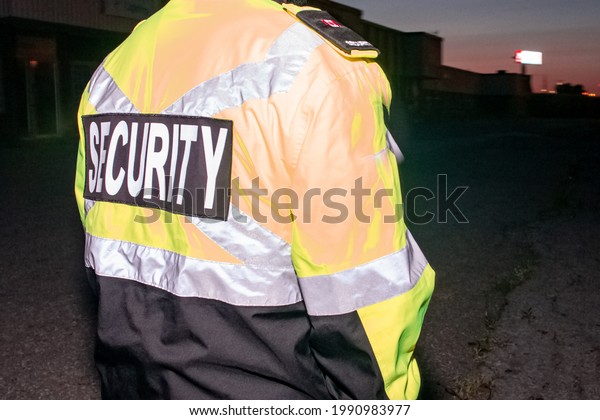 A closeup shot of a security guard\
patrolling busy street and city before sunset\
time