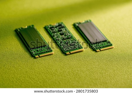 A close-up shot showcasing three M.2 NVMe Solid State Drives, highlighting their electronic components and metallic casings.