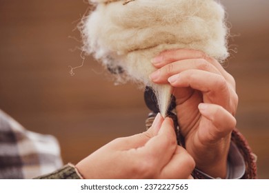 The closeup shot shows the woman's skilled hand spinning yarn. - Powered by Shutterstock