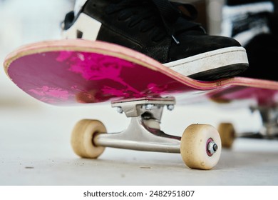 Close-up shot of skateboarder's feet on pink skateboard at skate park. Teenager is skateboarding. Leisure activity and extreme sport concept - Powered by Shutterstock