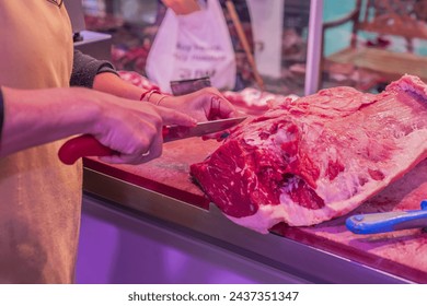 closeup shot, a skilled female butcher meticulously slices through a tender beef steak with precision and expertise using her sharp knife in the butcher shop - Powered by Shutterstock