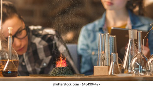 Close-up Shot Of A Small Chemistry Volcano. Young Boy And Girl Are Making Chemistry Experiments In A Garage At Home.