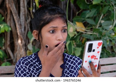 A Closeup Shot Of A South Asian Female Video Calling With A Shocked Expression