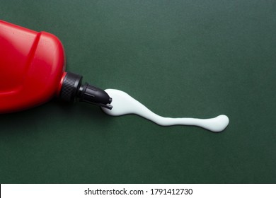 A closeup shot of spilled glue with a red container - Shutterstock ID 1791412730