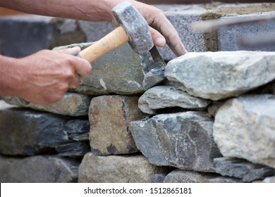 Close-up Shot Of A Stonemason Building A Dry Stone Wall.