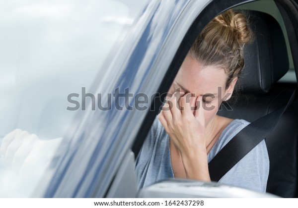 closeup shot\
of stressed young woman driver in a\
car