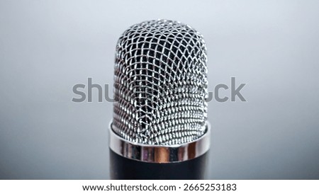 Close-up shot of a studio microphone with a silver mesh grill.