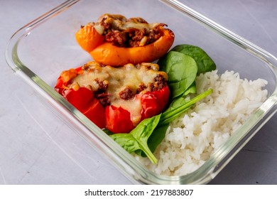 A Closeup Shot Of Stuffed Peppers With Spinach And Rice In A Clear Casserole On A Table