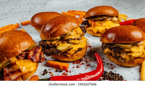 A Closeup Shot Of Tasty Smash Burgers, French Fries, And Red Spicy Peppers On The White Background