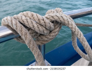 A Closeup Shot Of A Thick Rope Tied On A Boat Railing