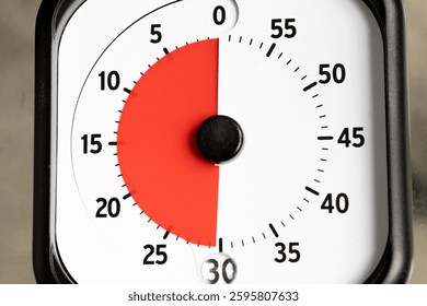 Close-up shot of a timer set to 30 minutes. The dial features a red section indicating the time elapsed, against a white background with black numbers.