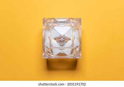 A Closeup Shot From Top Of A Closed Wedding, Engagement Ring Box, Isolated On A Yellow Studio Back Drop