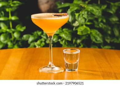 A Close-up Shot Of A Tropical Drink Served With Passionfruit Slice And A Glass Of A Syrup