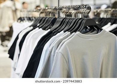 Closeup shot of t-shirts on hangers displayed on clothes rack at shop - Powered by Shutterstock