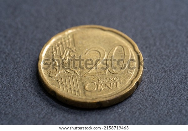 A\
closeup shot of a twenty Euro cent on a dark\
table