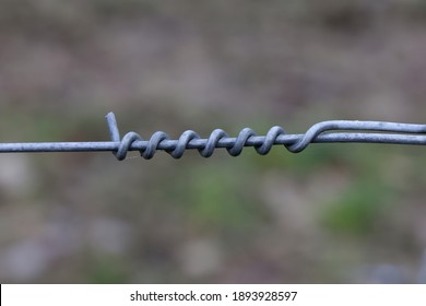 A Closeup Shot Of Twisted Metal Wire On An Electric Fence