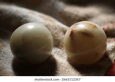 A close-up shot of two eggs lying on a cloth, ideal for use in food, still life or nature photography.