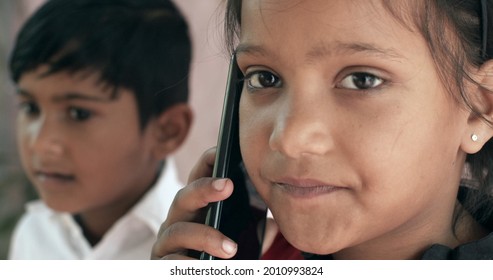 A Closeup Shot Of Two South Asian Children Speaking On The Phone Together