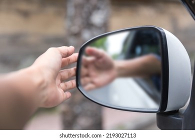 Close-up shot unrecognizable man adjusting side mirror on his car