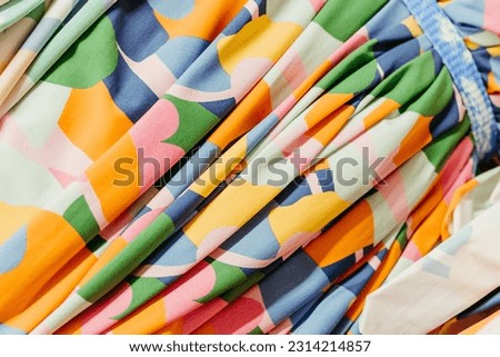 A closeup shot of a vibrant, multicolored fabric with a variety of hues and patterns