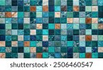 A close-up shot of a wall tiled with small, colorful mosaic squares in shades of teal, blue, and green.