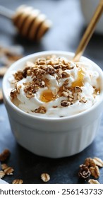 A close-up shot of a white bowl filled with creamy yogurt, topped with granola and a drizzle of honey.