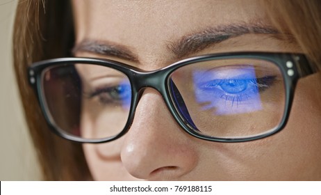 Close-up shot of woman eyes in glasses reflecting a working computer blue screen - Shutterstock ID 769188115