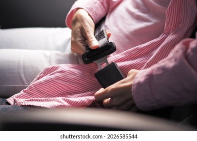 Close-up Shot Of A Woman Fastening Her Seat Belt In Public Bus.
