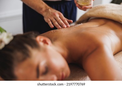 Close-up shot of a woman getting an exfoliating massage with salt scrubbing at the beauty salon. - Shutterstock ID 2197770769