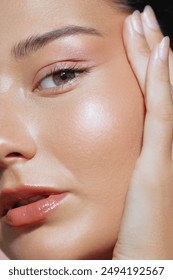 A close-up shot of a woman with glowing skin and natural makeup in a studio setting. Perfect for promoting face care products, moisturizing creams, and skincare routines, this high-quality image