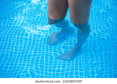 Closeup shot of woman legs in the pool, shallow water pool