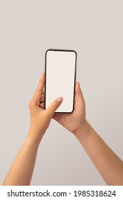 Closeup Shot Of A Woman Typing On Mobile Phone Isolated On White Background.. Girl's Hand Holding A Modern Smartphone And Pointing With Figer. Blank Screen. Selective Focus.