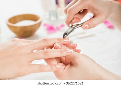 Closeup Shot Of A Woman Using A Cuticle Clipper To Give A Nail Manicure. Woman Remove A Cuticle Nail With Nail Clipper. Shallow Depth Of Field With Focus On Cuticle Clipper.
