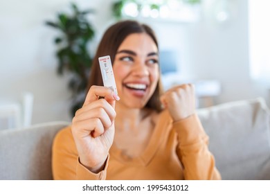 Close-up shot of woman's hand holding a negative test device. Happy young woman showing her negative Coronavirus - Covid-19 rapid test. Focus is on the test.Coronavirus - Shutterstock ID 1995431012