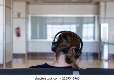 A Close-up Shot Of A Woman's Head With Headphones From The Back 