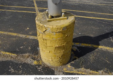 A Closeup Shot Of The Yellow Concrete Pier Of A Parking Lot Light Pole In Missouri