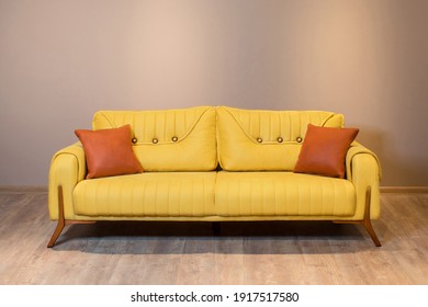 A closeup shot of a yellow modern couch on a wooden floor