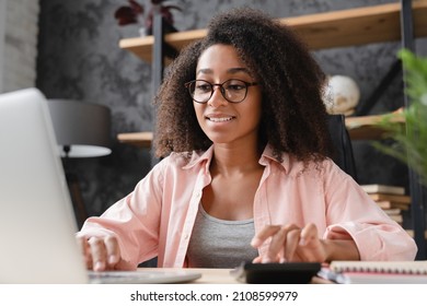 Closeup Shot Young African Student Worker Businesswoman Freelancer Counting Funds Domestic Bills On Calculator While Using Laptop For E-banking, Paperwork, Debt And Loan