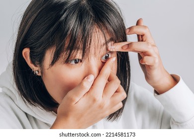 Close-up shot of young asian woman wearing contact lens. vision correction, advertising medical products